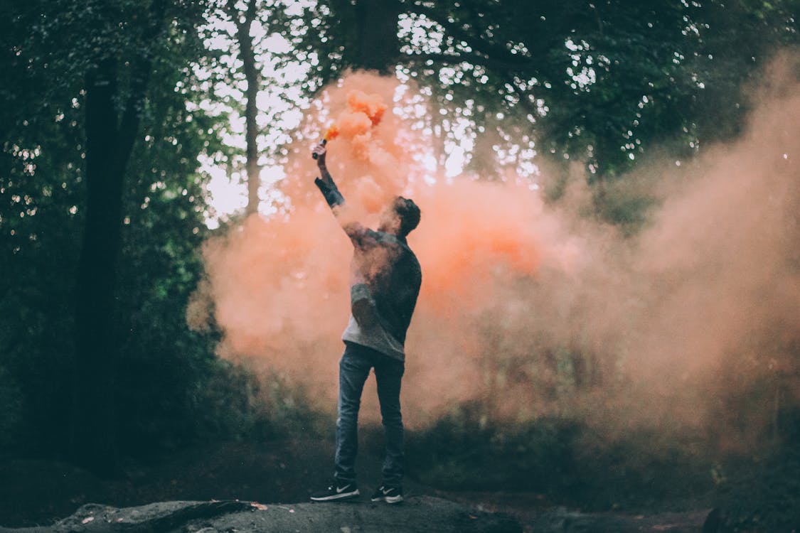 Free Man Throwing Peach-colored Powder Stock Photo